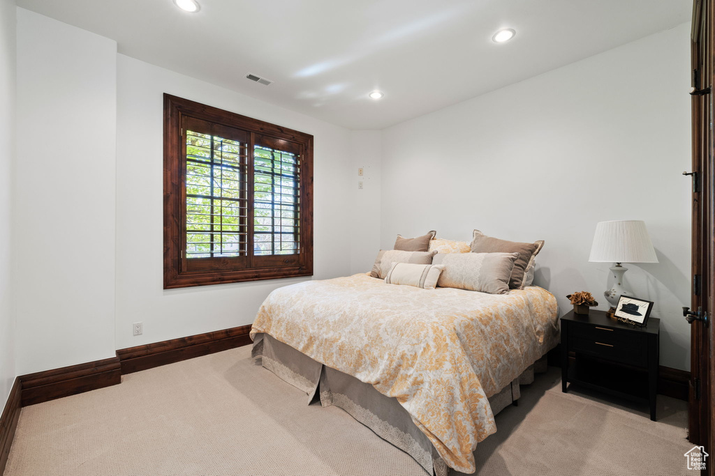 Bedroom featuring light carpet, baseboards, and visible vents
