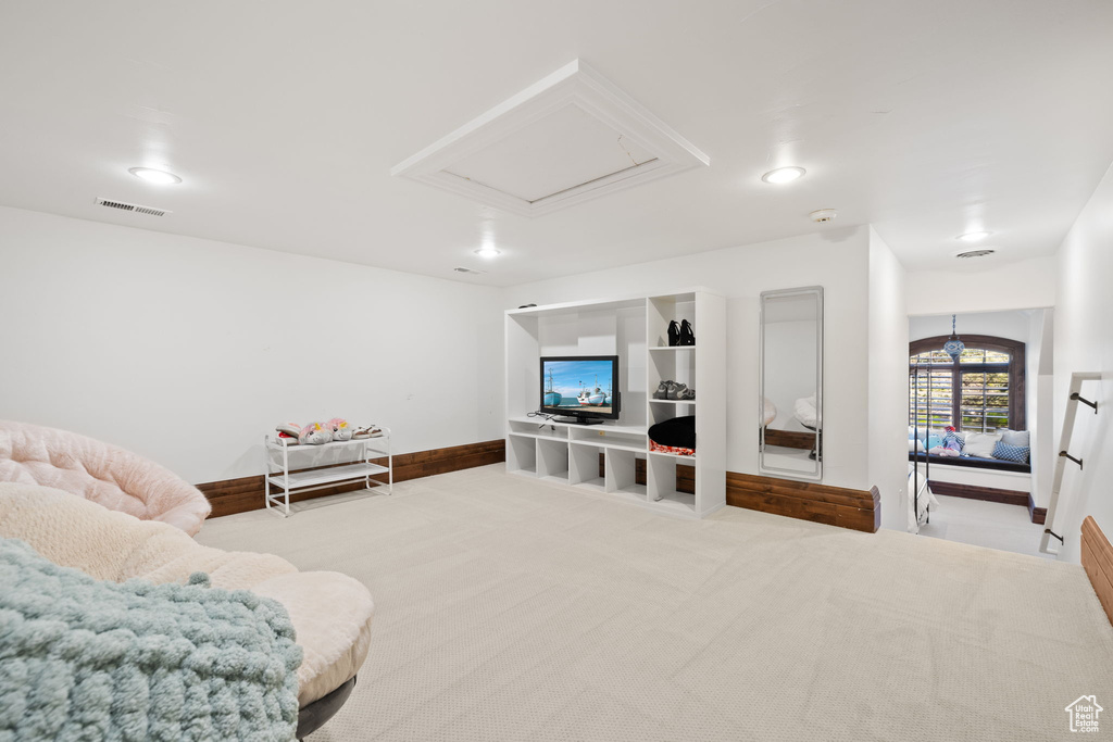 Carpeted living room with baseboards, visible vents, and recessed lighting