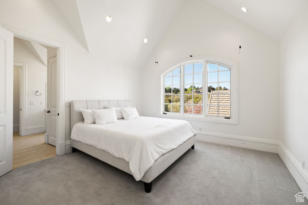 Bedroom featuring baseboards, recessed lighting, light colored carpet, and high vaulted ceiling