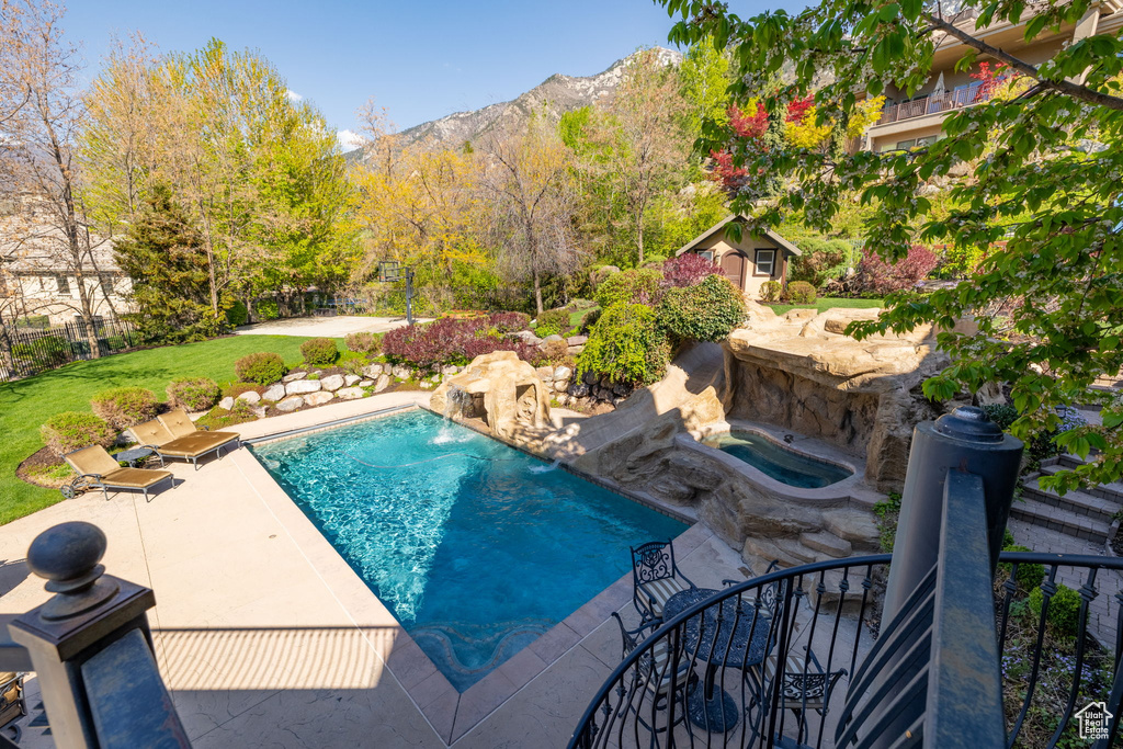 Pool featuring a patio area, a mountain view, and an outbuilding