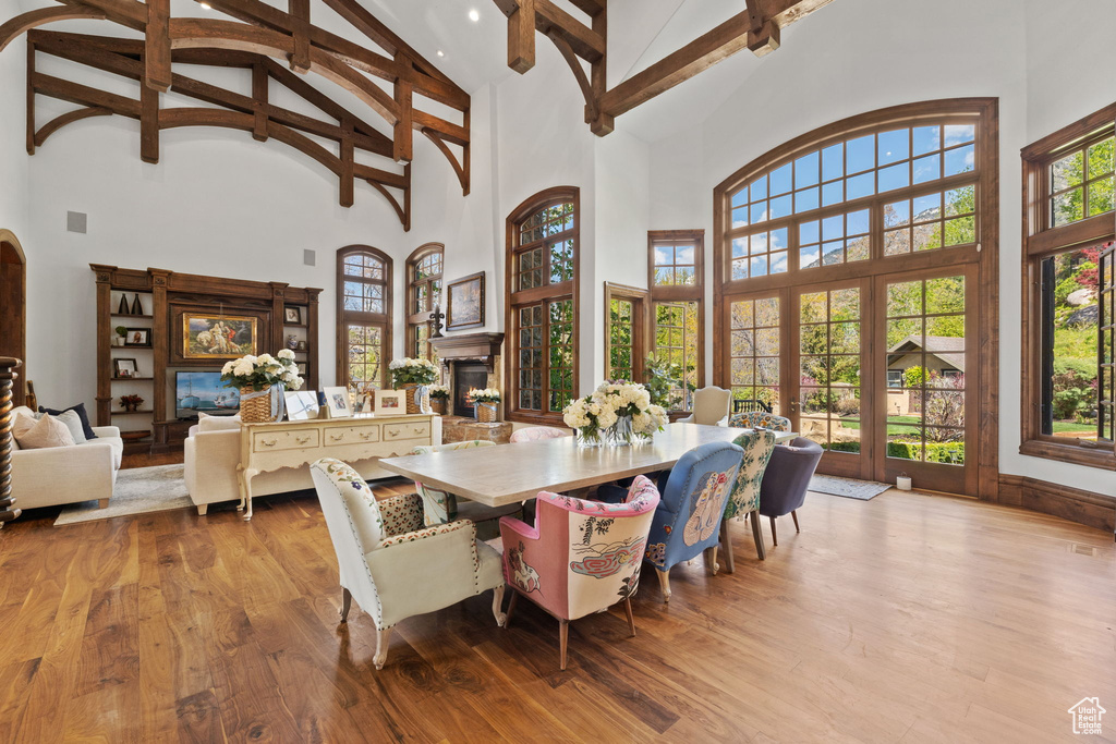 Dining area featuring beamed ceiling, high vaulted ceiling, and a lit fireplace
