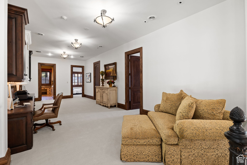 Living area featuring light carpet and baseboards