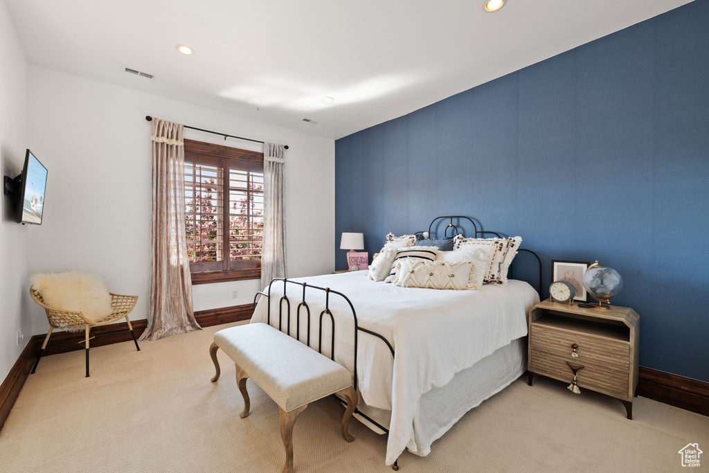 Bedroom featuring light colored carpet, visible vents, and baseboards