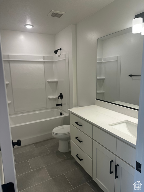 Full bath featuring vanity, shower / bathtub combination, toilet, and tile patterned flooring