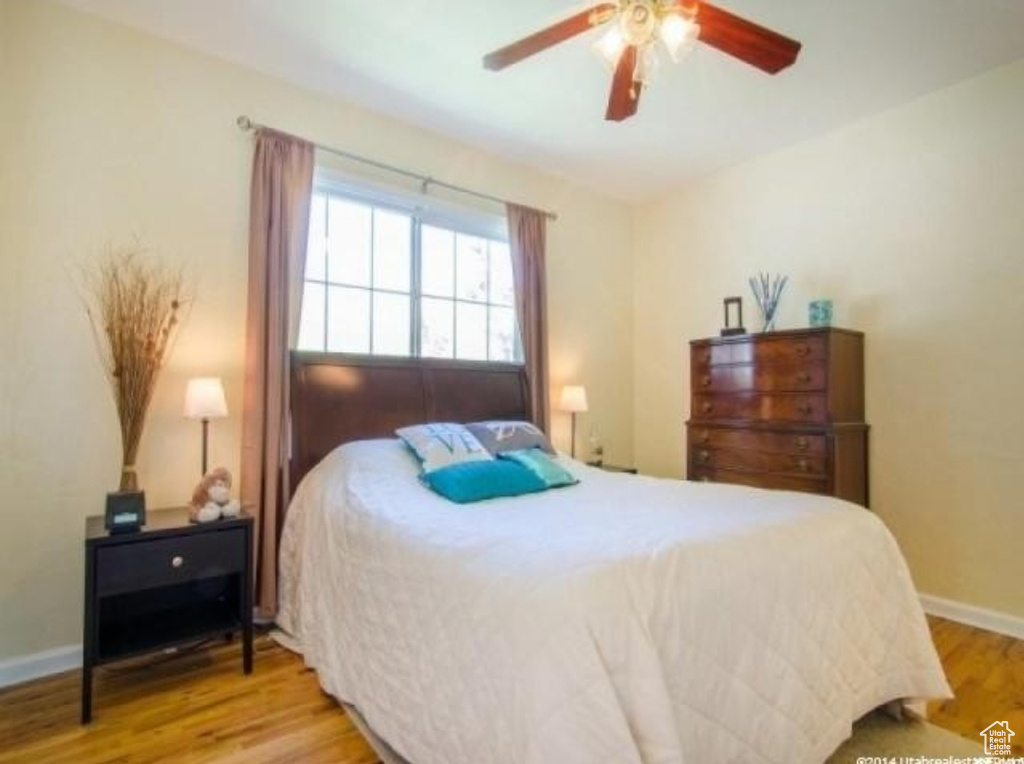 Bedroom with wood finished floors, baseboards, and ceiling fan