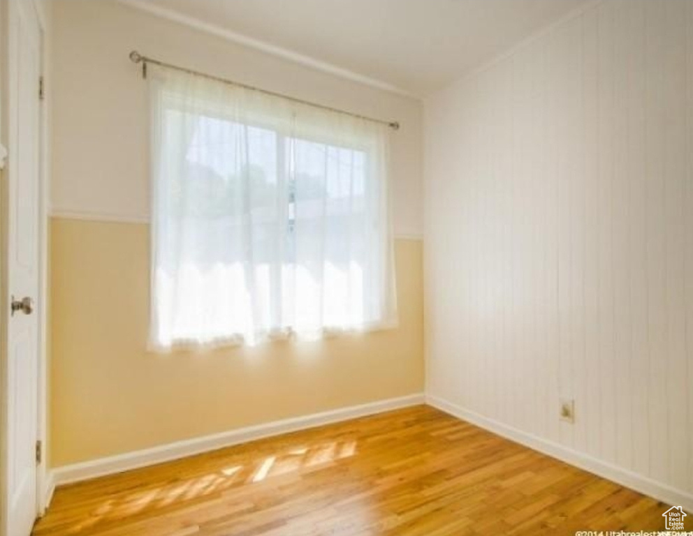 Empty room featuring wood finished floors and baseboards