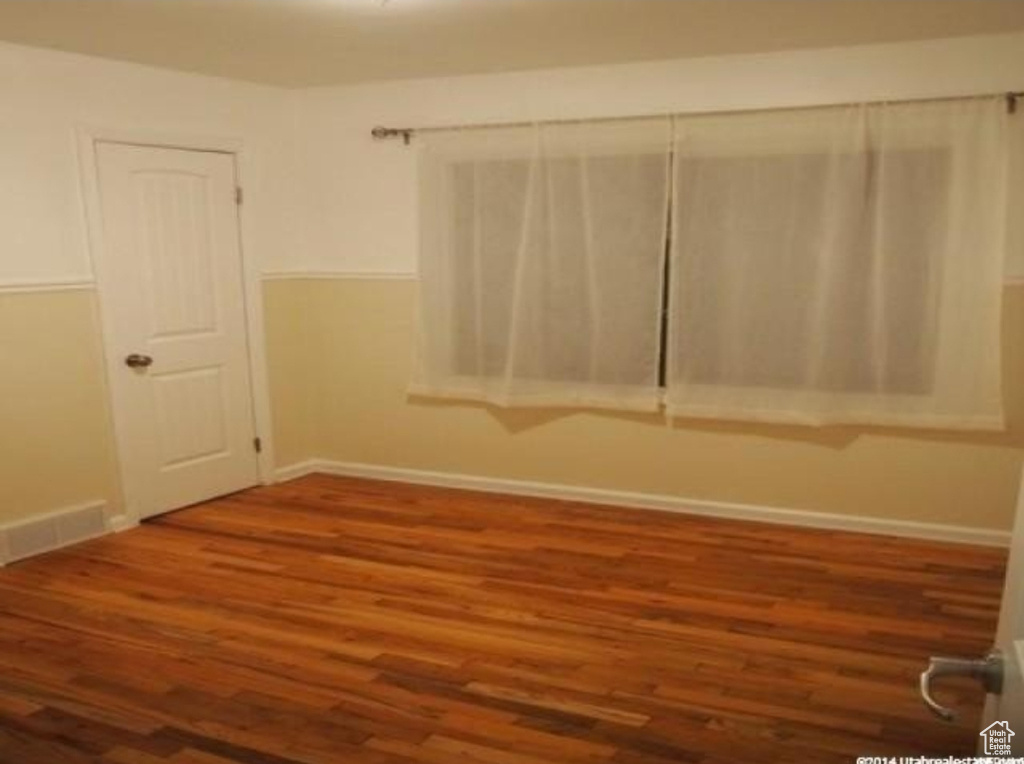 Spare room featuring wood finished floors and baseboards