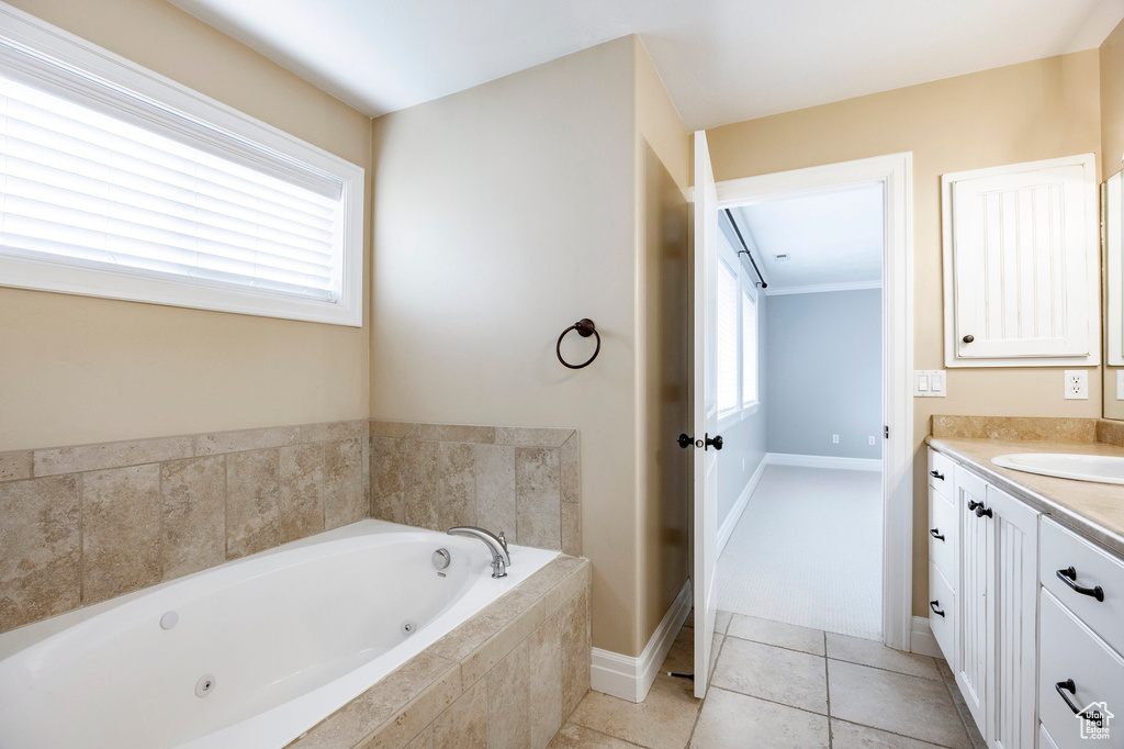 Bathroom with baseboards, tile patterned floors, vanity, and a whirlpool tub