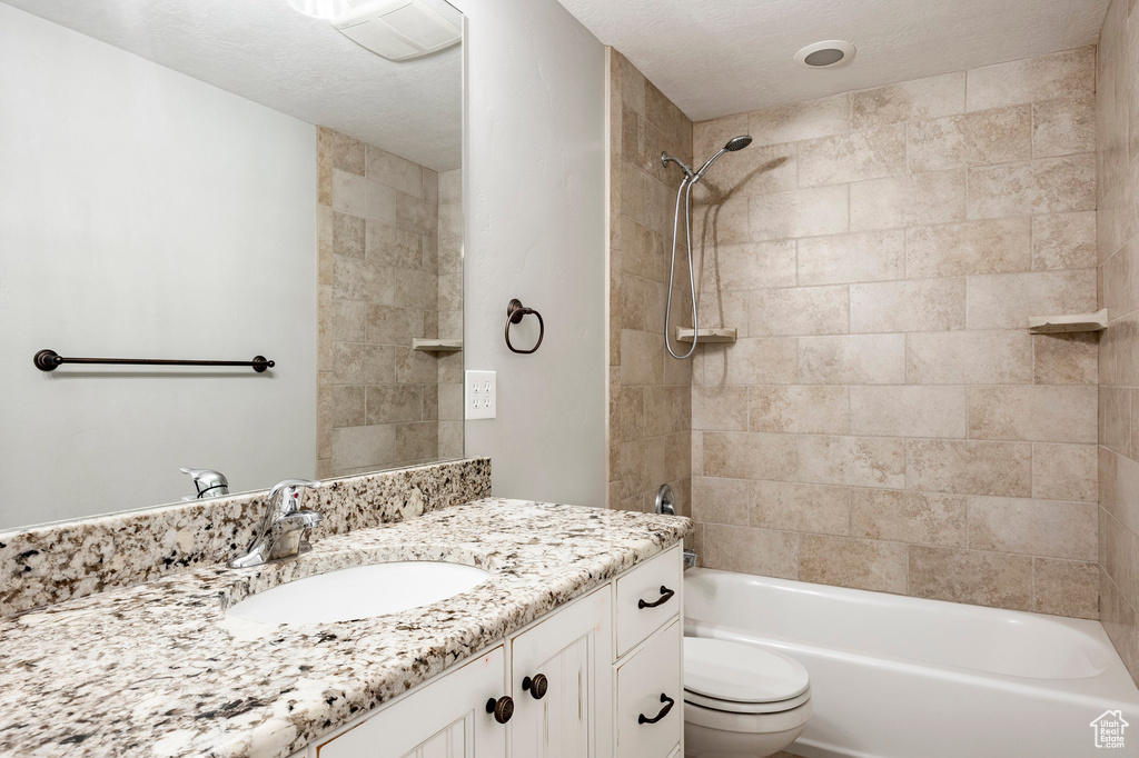 Full bath with vanity, toilet, and shower / washtub combination