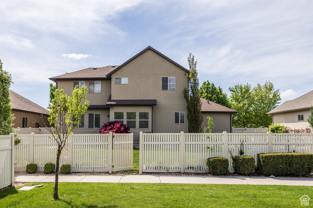 Rear view of house featuring stucco siding and a shingled roof