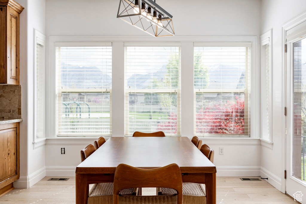 Dining room featuring visible vents, light wood-style flooring, and baseboards