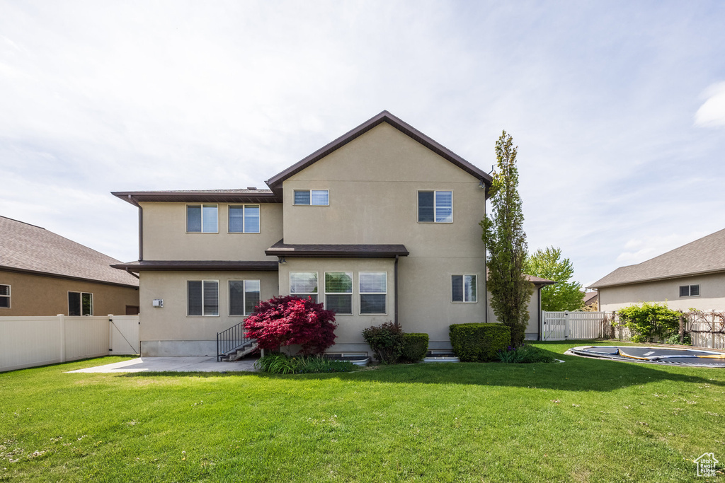 Rear view of house with a gate, entry steps, a patio, and stucco siding