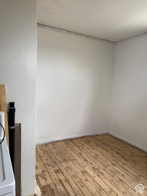 Empty room with wood-type flooring, baseboards, and washer / clothes dryer