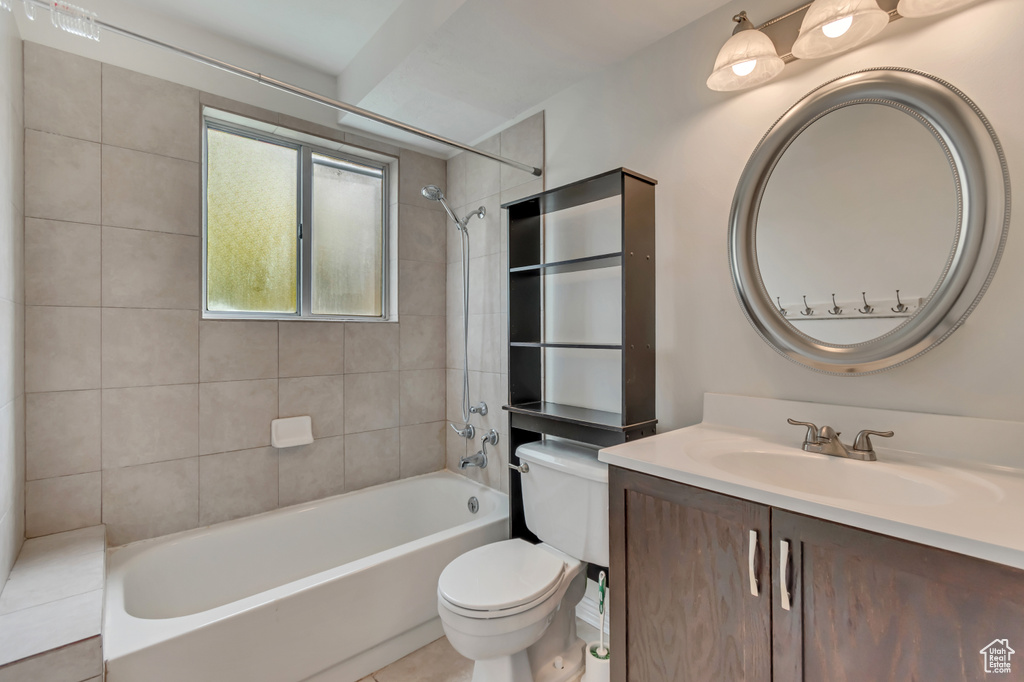 Bathroom with toilet, vanity, washtub / shower combination, and tile patterned flooring