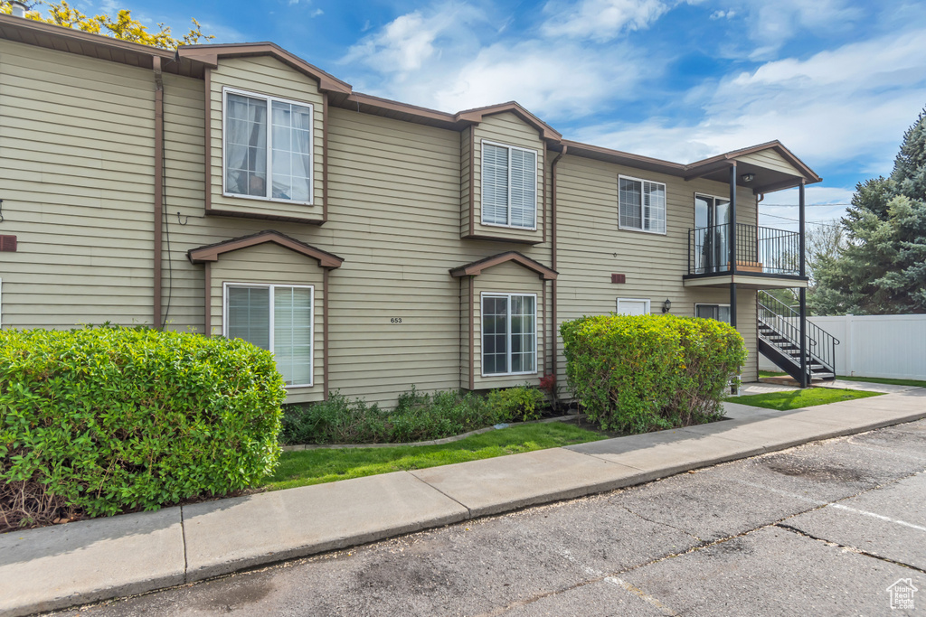 Townhome / multi-family property featuring stairs, a balcony, and fence