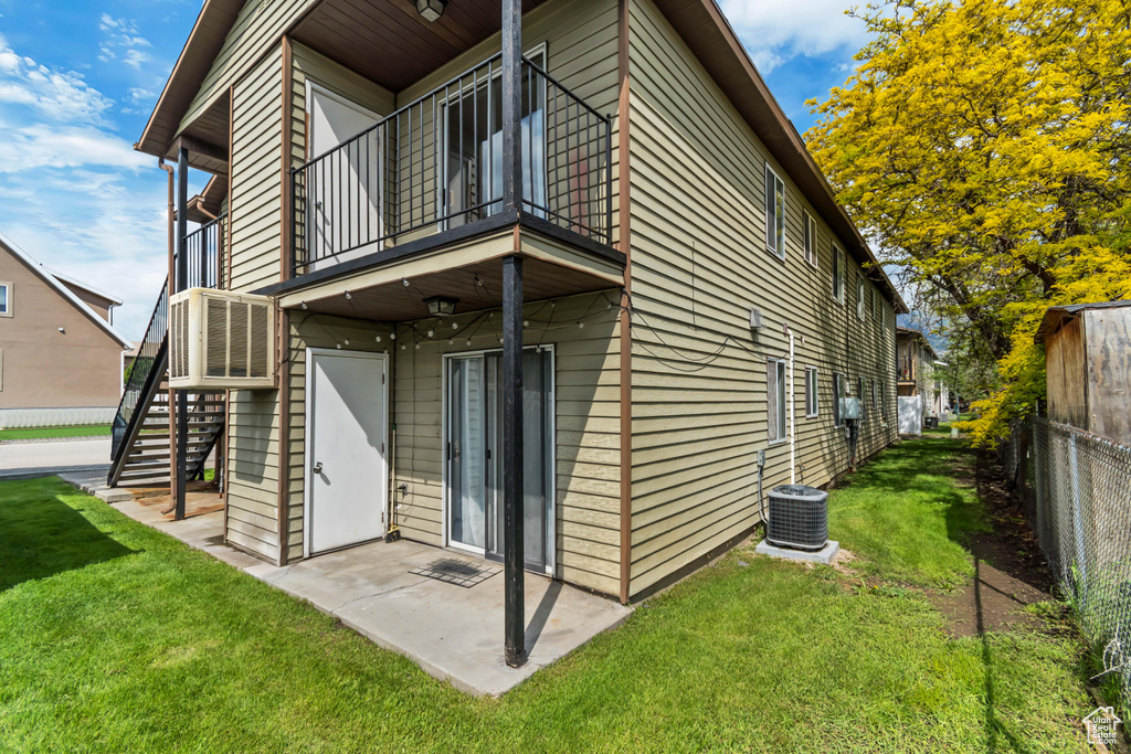 Rear view of house featuring a balcony, stairway, a patio area, and central AC unit