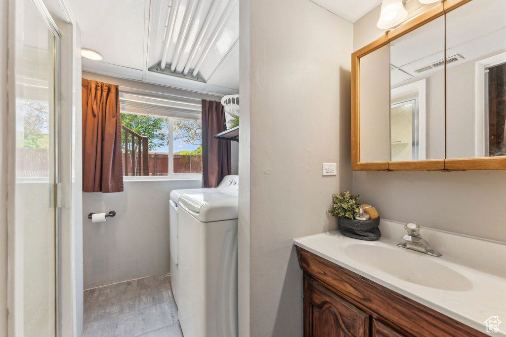 Bathroom featuring washer and dryer, vanity, and baseboards