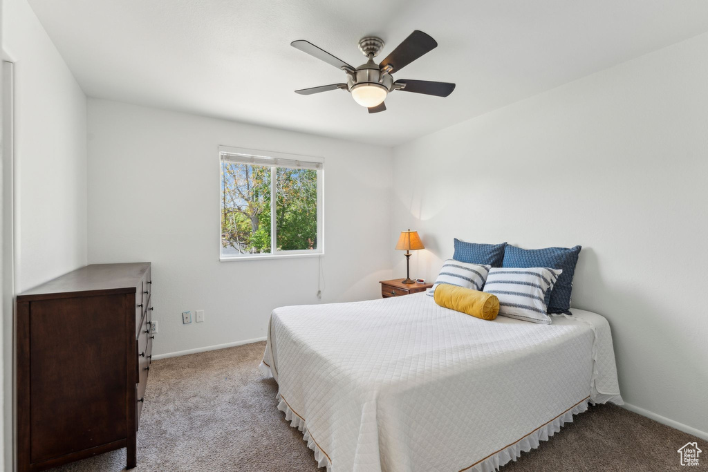 Carpeted bedroom featuring baseboards and ceiling fan