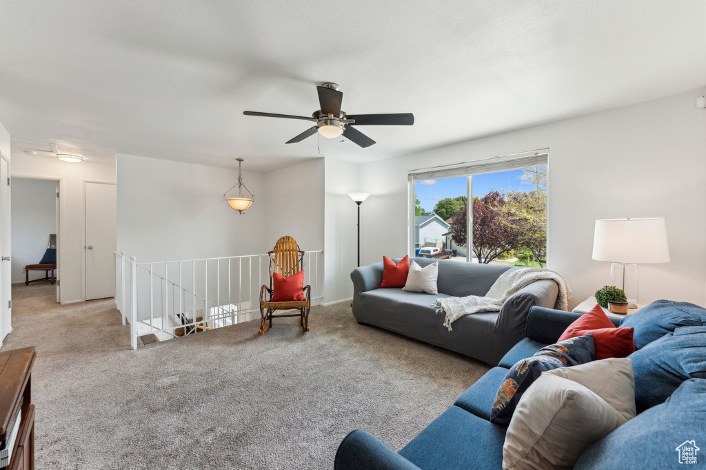 Carpeted living room featuring ceiling fan