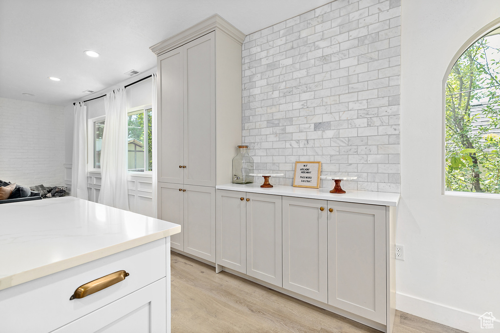 Kitchen with a wealth of natural light, light countertops, and light wood-style floors
