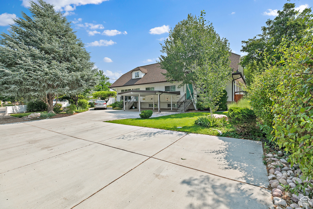 View of front of property with stairway, concrete driveway, and a front yard
