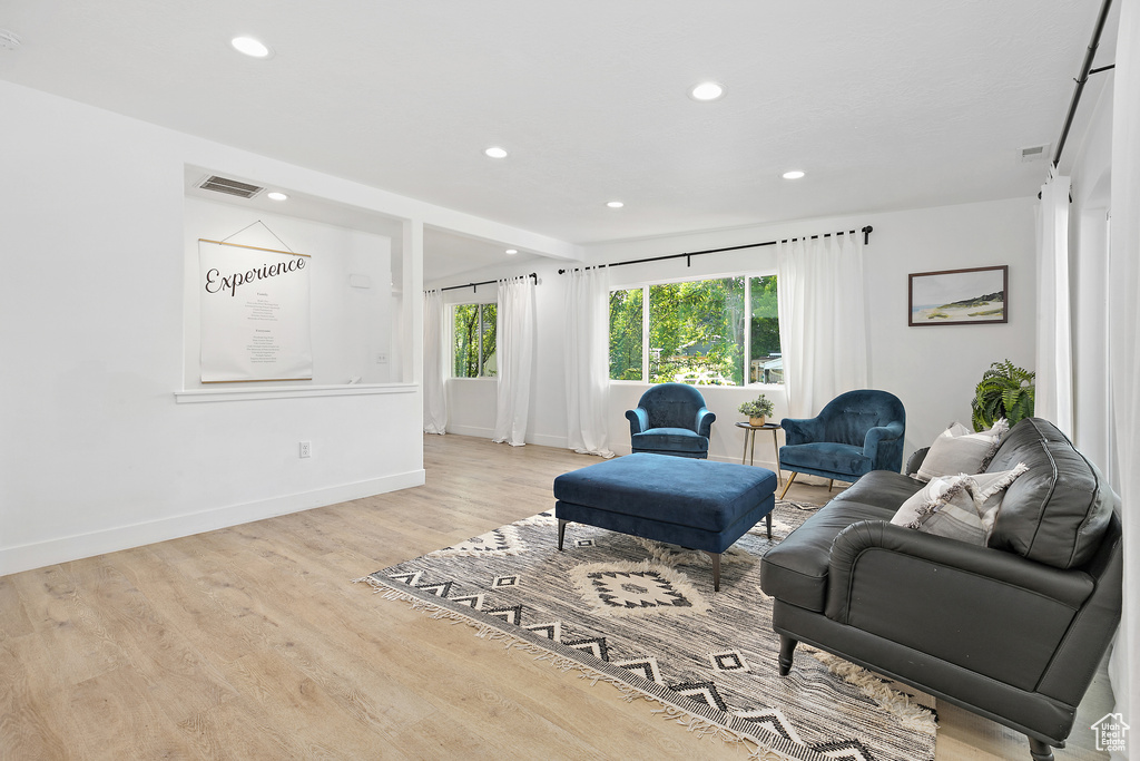 Living area featuring recessed lighting, baseboards, visible vents, and wood finished floors