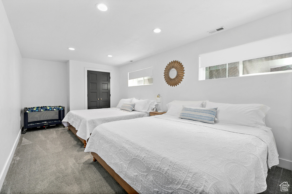 Carpeted bedroom with recessed lighting, baseboards, visible vents, and multiple windows