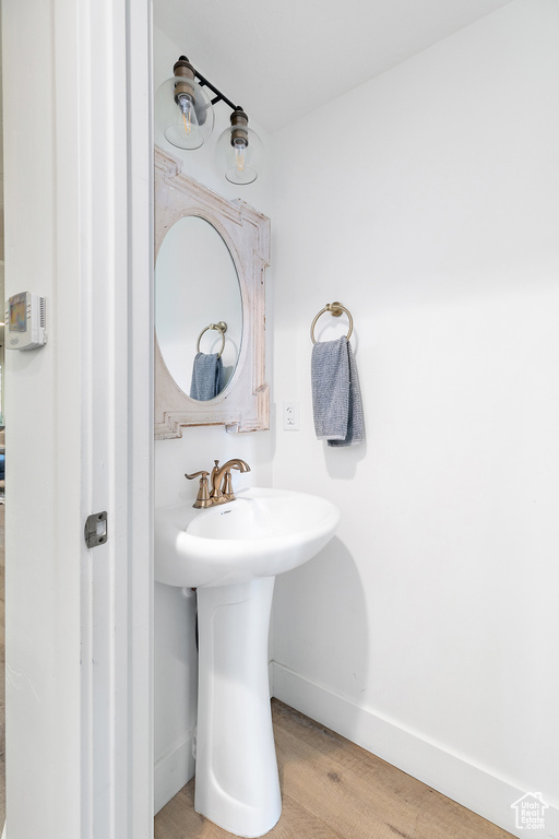 Bathroom with a sink, baseboards, and wood finished floors