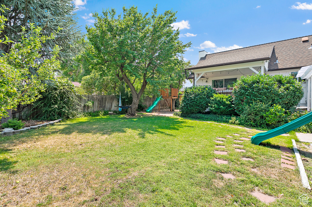 View of yard with a playground and a fenced backyard