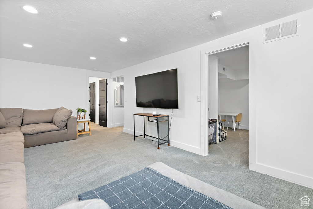 Carpeted living room with baseboards, recessed lighting, and visible vents