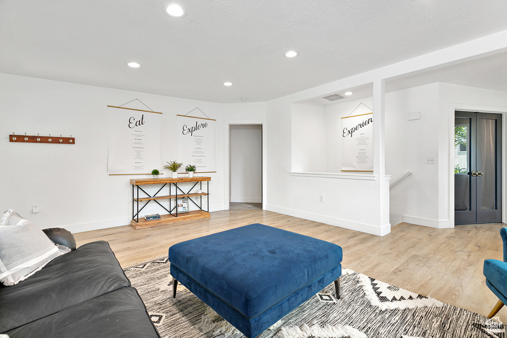 Living room featuring light wood-style flooring, baseboards, and recessed lighting