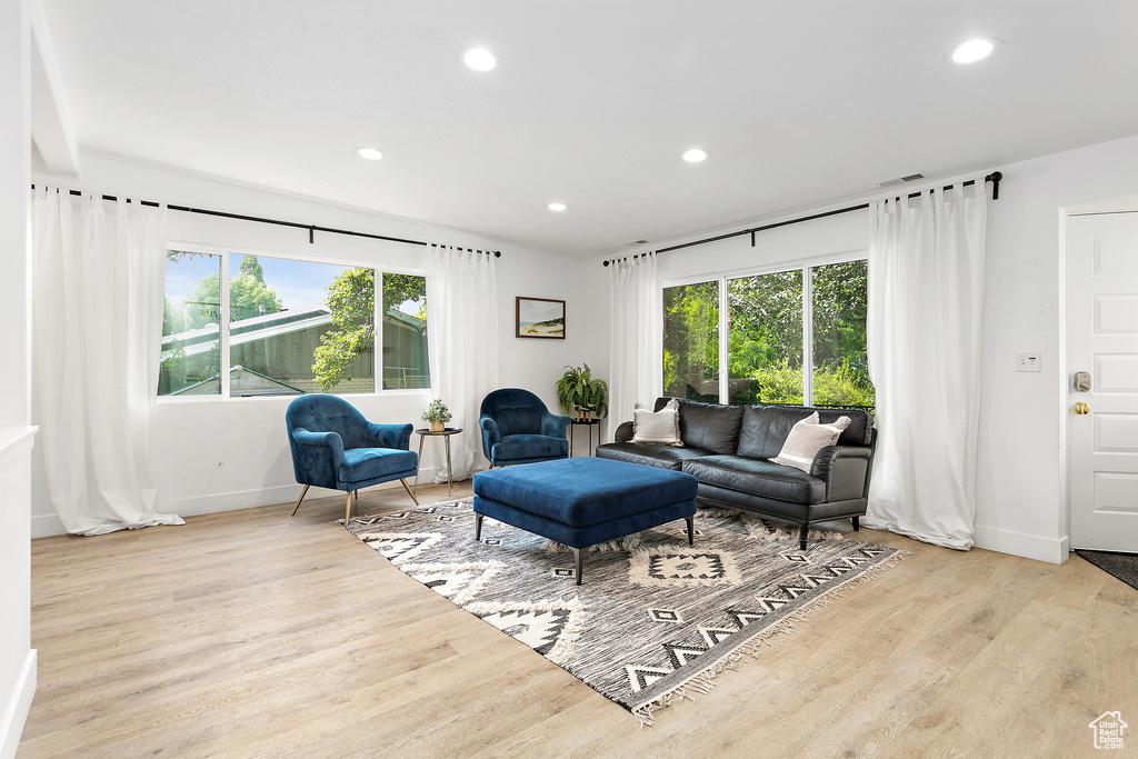Living room with recessed lighting, a wealth of natural light, baseboards, and wood finished floors