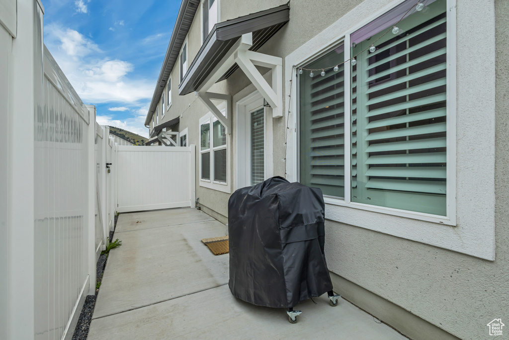 View of patio featuring fence, a gate, and area for grilling