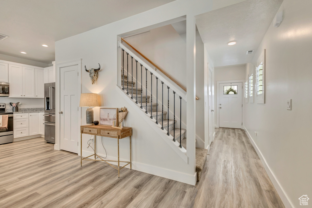 Stairway featuring wood finished floors, recessed lighting, and baseboards