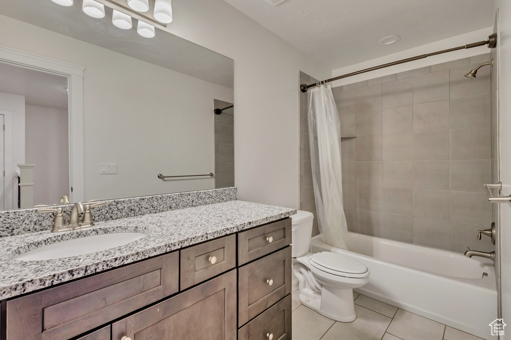 Full bath featuring shower / bath combination with curtain, tile patterned flooring, toilet, and vanity