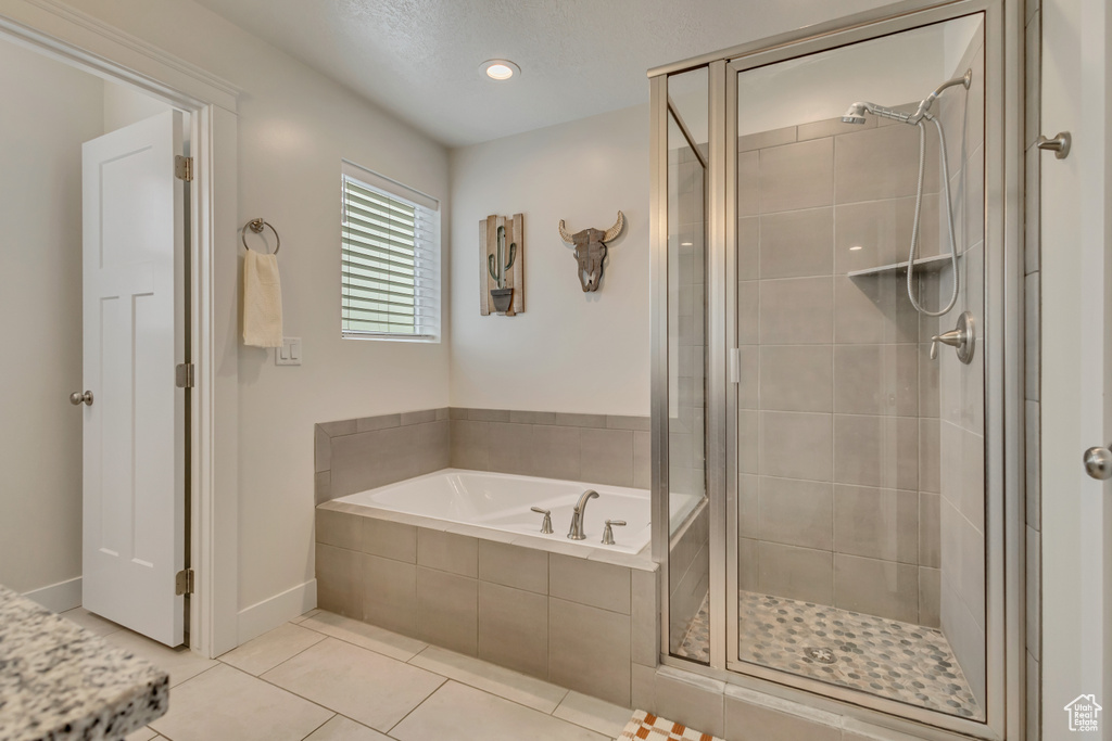 Bathroom with a stall shower, a bath, tile patterned floors, baseboards, and recessed lighting