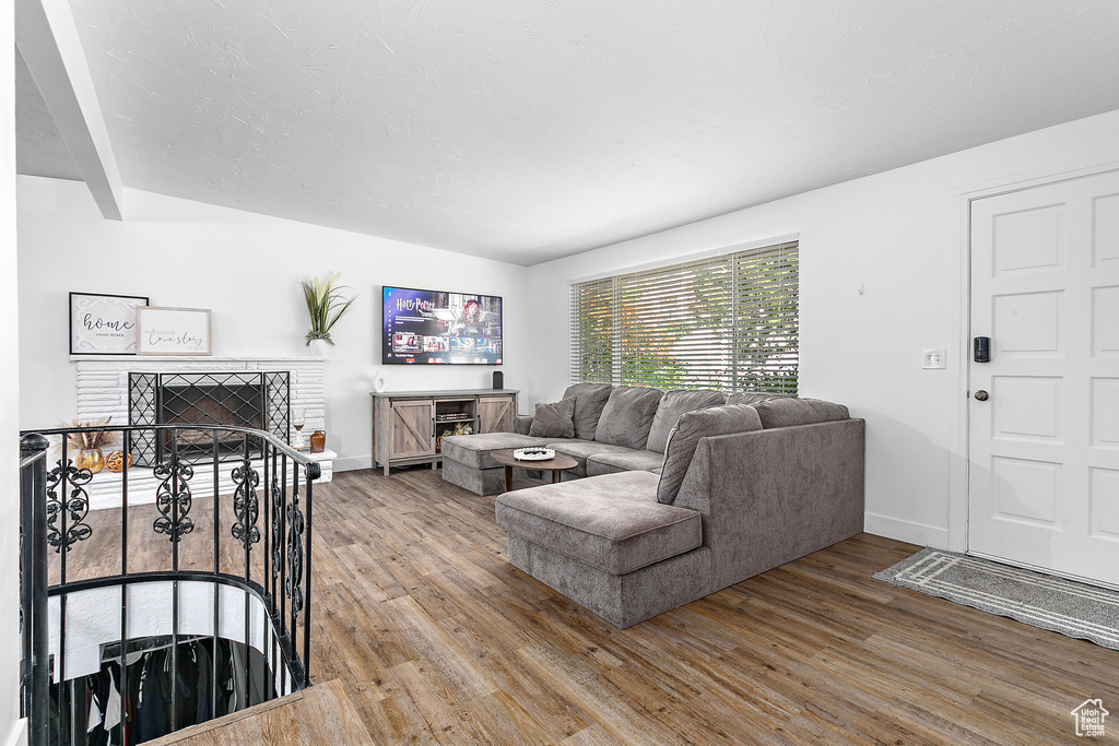 Living room featuring a fireplace, baseboards, and wood finished floors