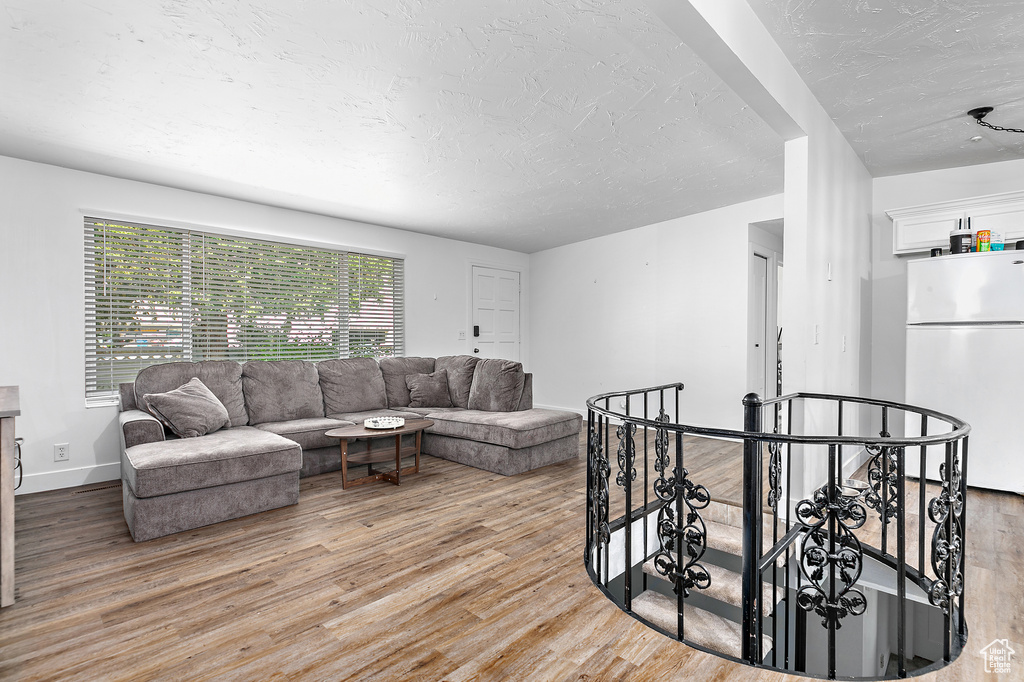 Living room featuring a textured ceiling, wood finished floors, and baseboards