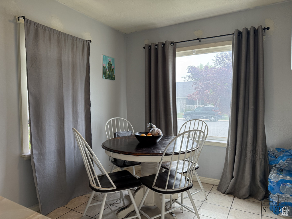 Dining space featuring light tile patterned floors and healthy amount of natural light