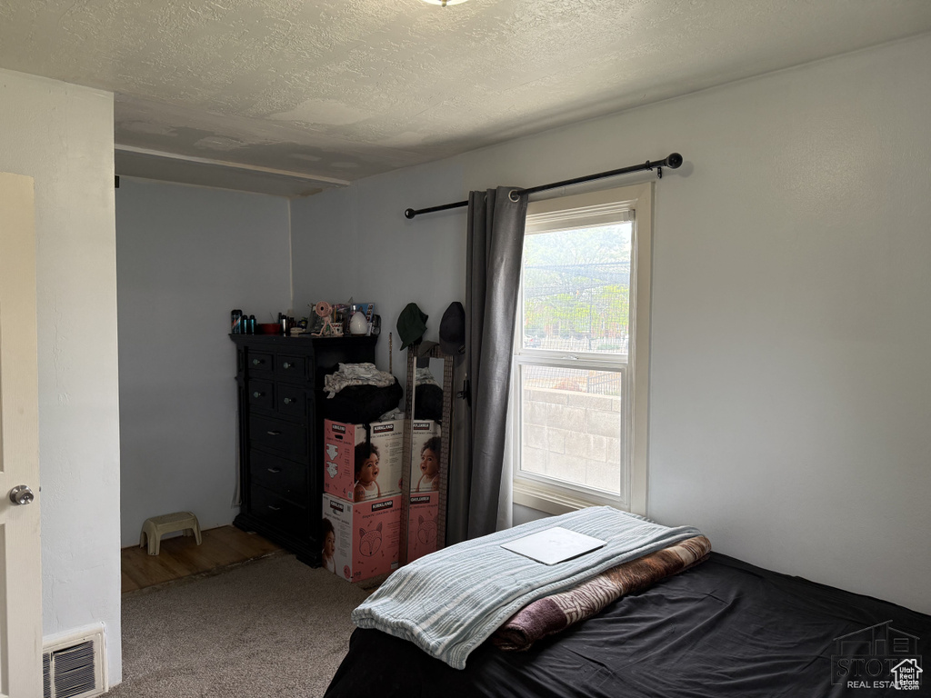 Carpeted bedroom featuring a textured ceiling