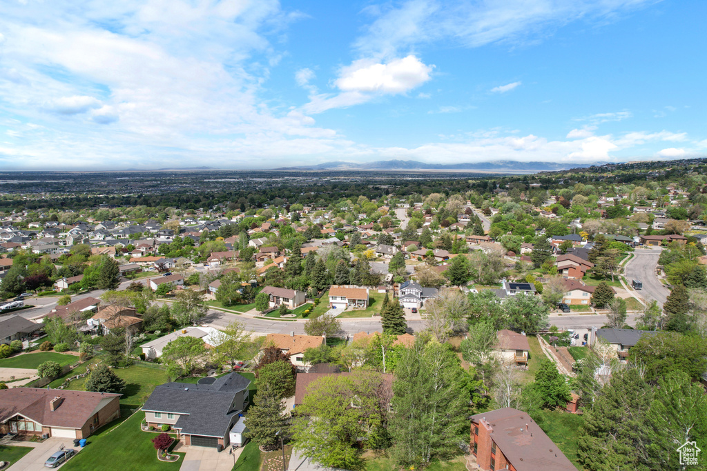 Aerial view of property and surrounding area with nearby suburban area and a mountainous background