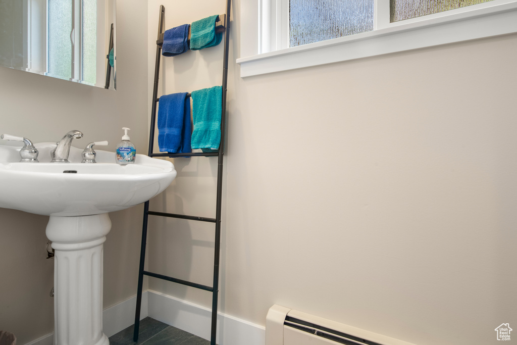 Bathroom with a baseboard radiator, baseboards, and a sink