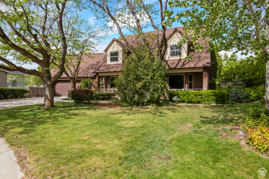Cape cod-style house with covered porch, concrete driveway, a garage, and roof with shingles