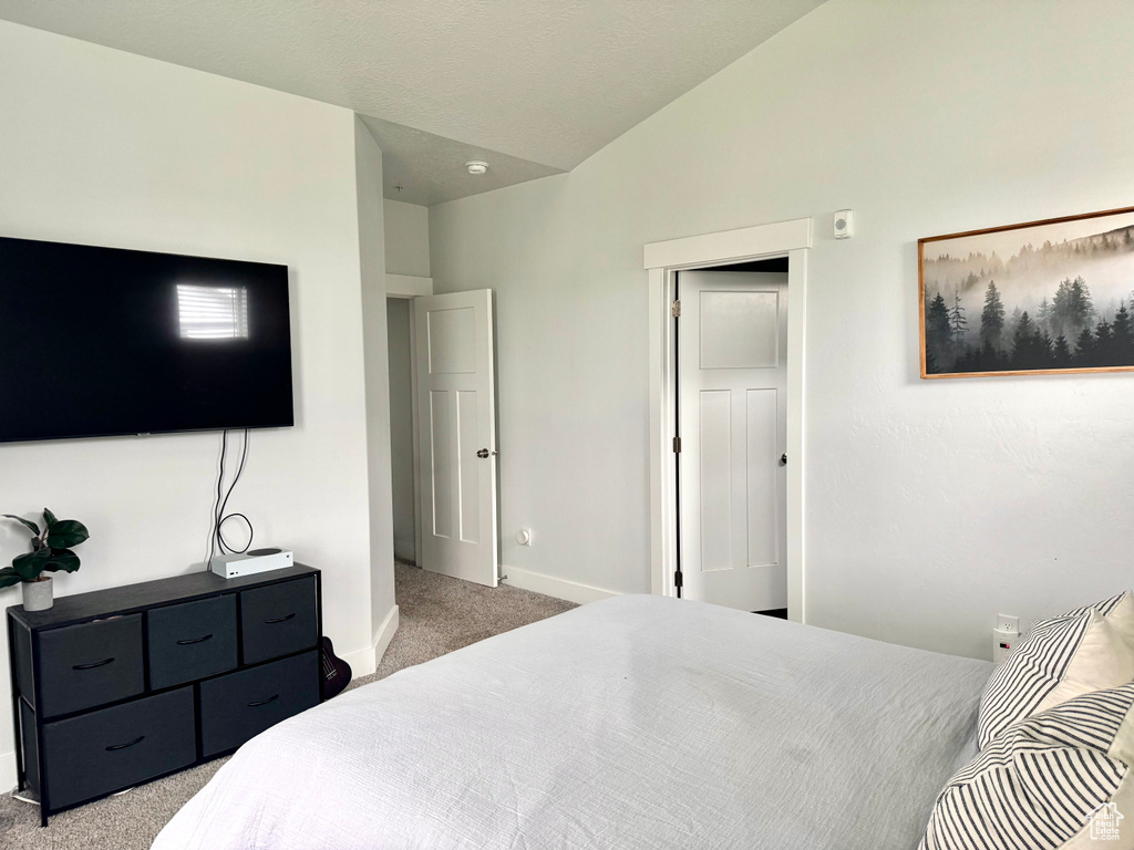 Bedroom with baseboards, lofted ceiling, and carpet floors