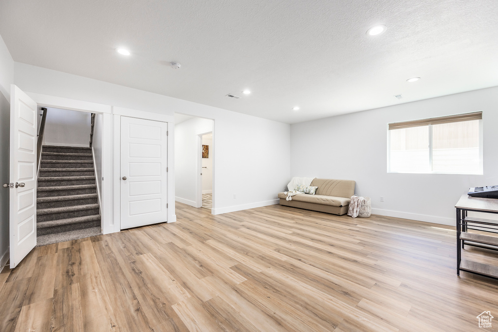 Unfurnished room with light wood-type flooring, recessed lighting, stairway, and baseboards