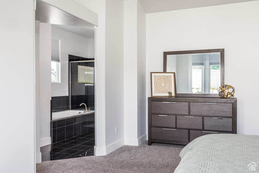 Carpeted bedroom with multiple windows and baseboards