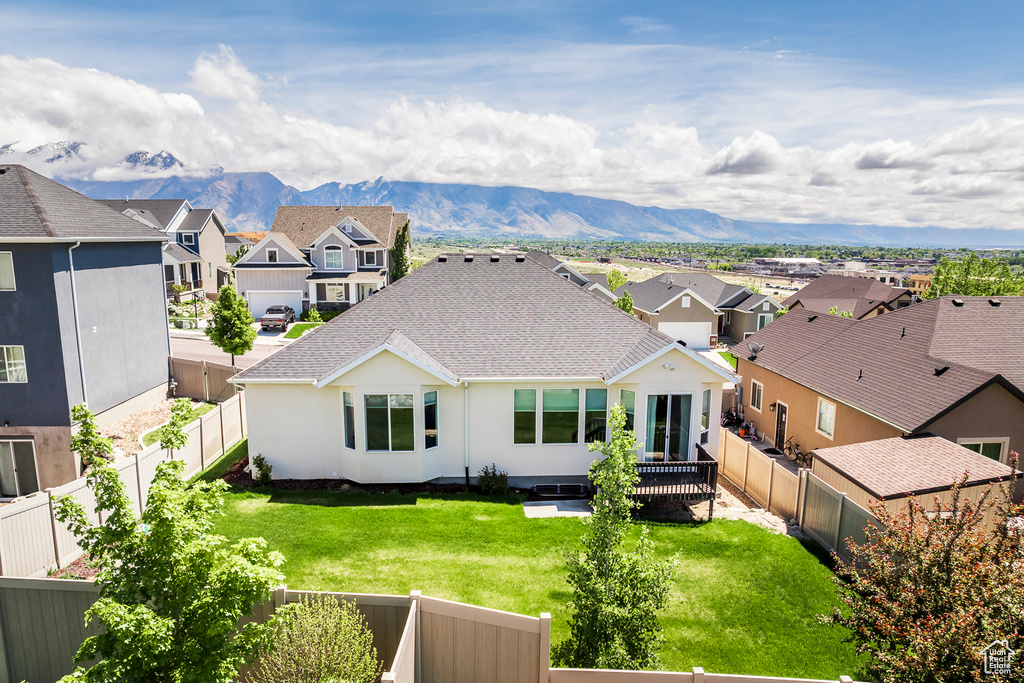Rear view of house featuring a residential view, a shingled roof, a mountain view, and stucco siding
