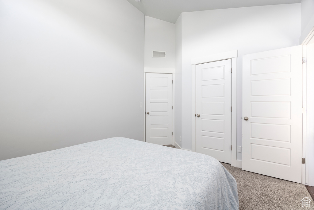 Bedroom featuring carpet, a closet, and vaulted ceiling