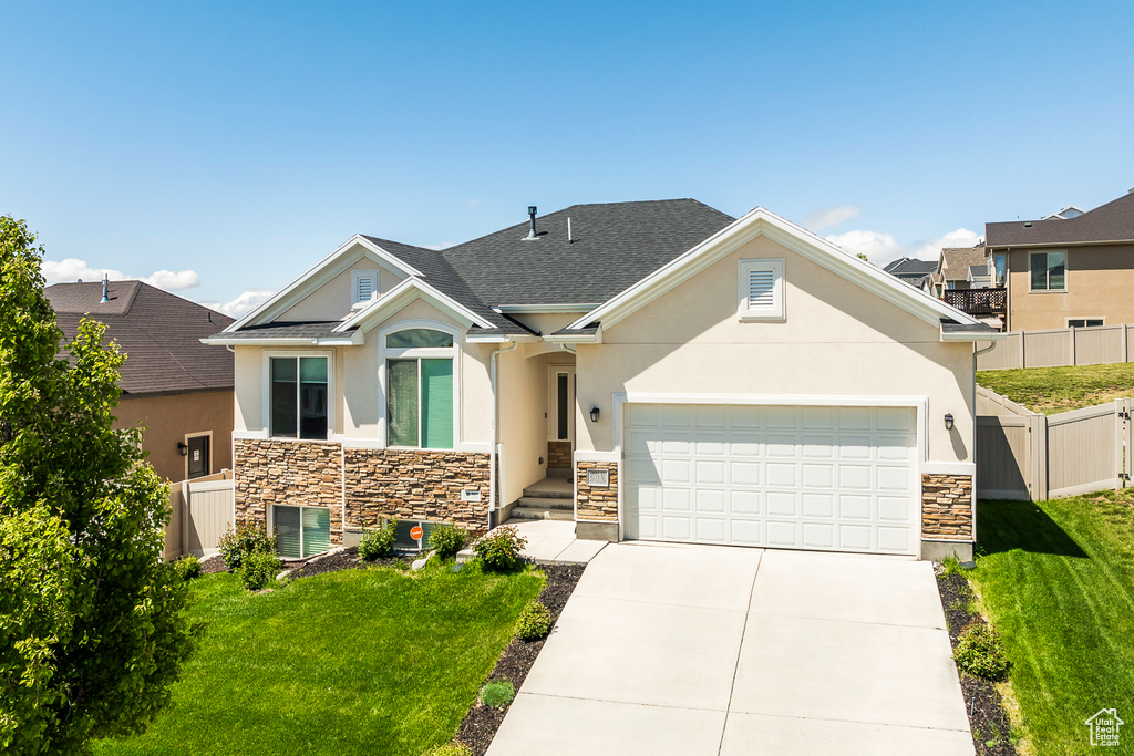 Craftsman-style home featuring stone siding, stucco siding, a garage, concrete driveway, and central AC