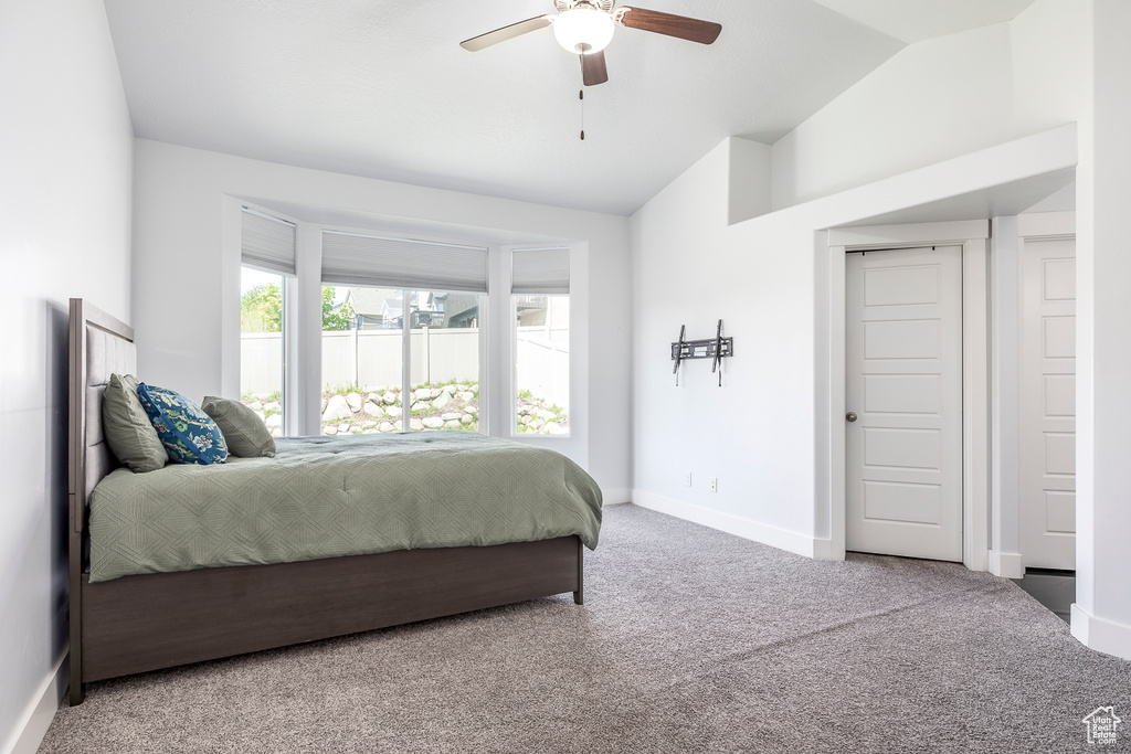 Bedroom with carpet floors, vaulted ceiling, baseboards, and ceiling fan